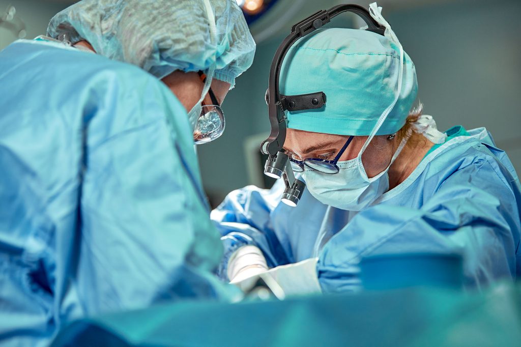 picture of a surgeon doing surgery with the help of an OR tech