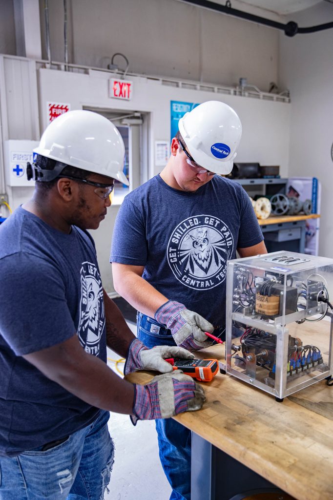 Pipeline students taking an output voltage reading on a rectifier at Central Tech