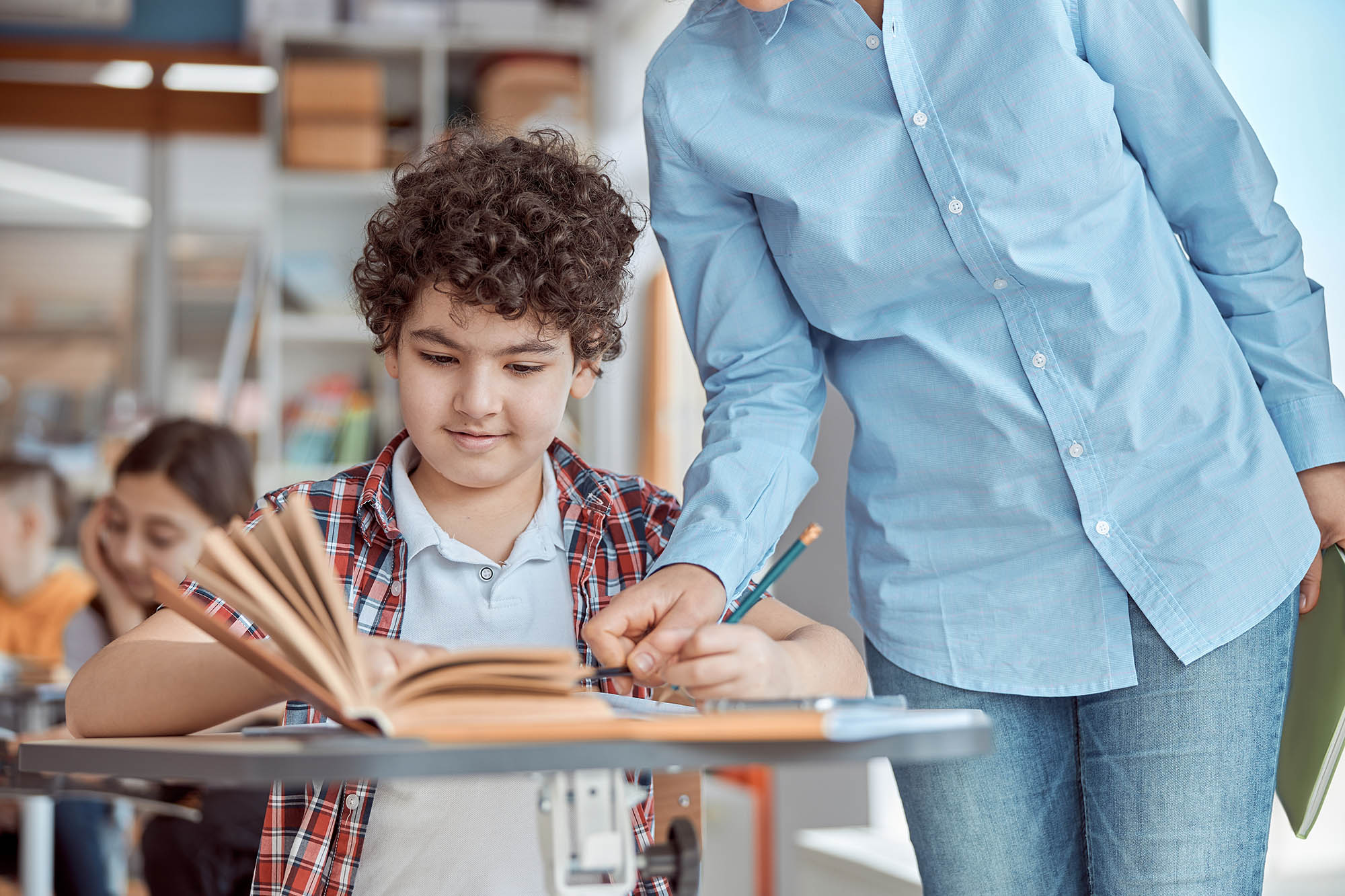 boy getting help from teacher at school