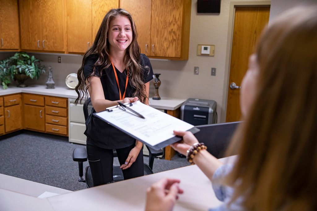 medical front office employee greeting a patient