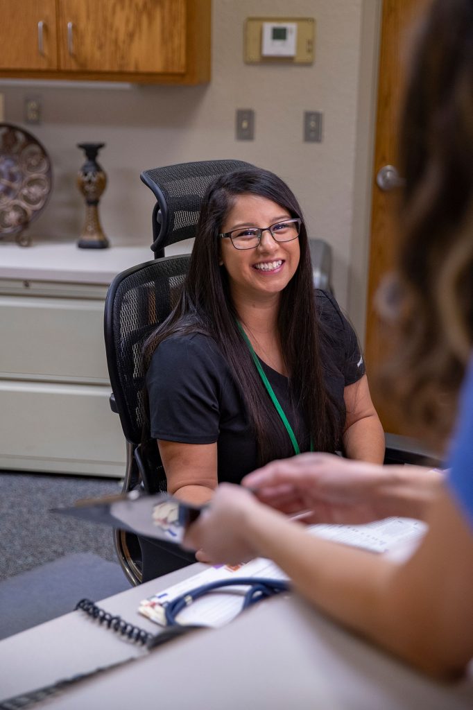 medical front office employee greeting a patient