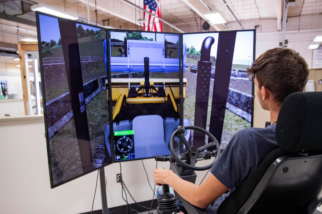 student operating a heavy equipment simulator