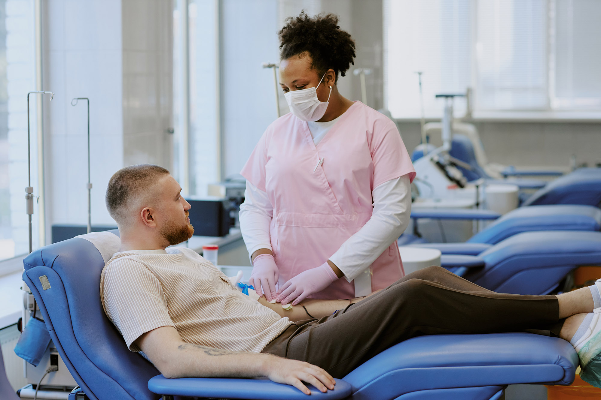 phlebotomist drawing blood from man